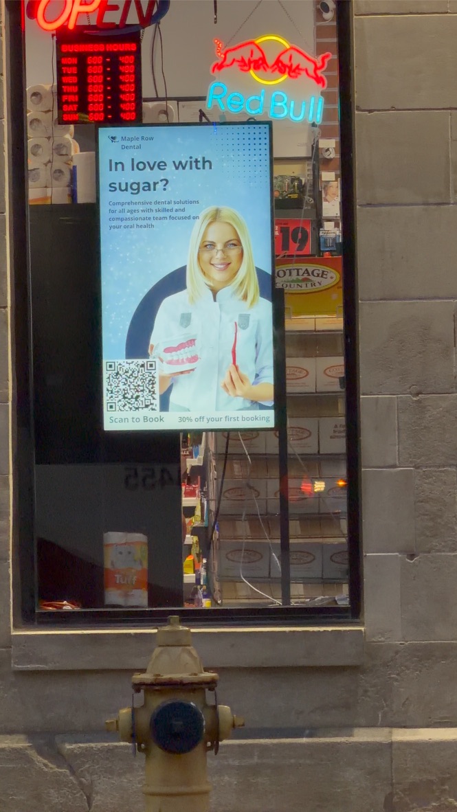 Digital window screen running an ad in a Queen Street West storefront window
